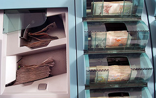 Our business: Pre issue image featuring a banknote processing machine.