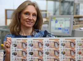 Image of Bank of England Chief Cashier Victoria Cleland holding a sheet of ten pound banknotes.